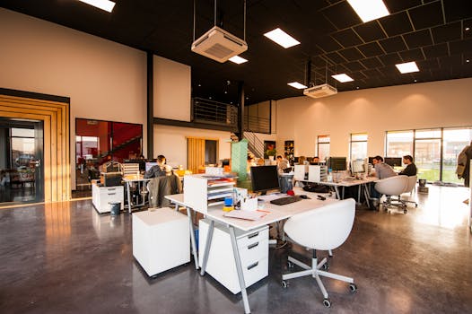 About Us A spacious and modern open-plan office with natural lighting and employees working at desks.